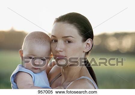 Woman holding baby in nature close-up View Large Photo Image Stock Photography - Woman holding baby in nature close-up. Fotosearch