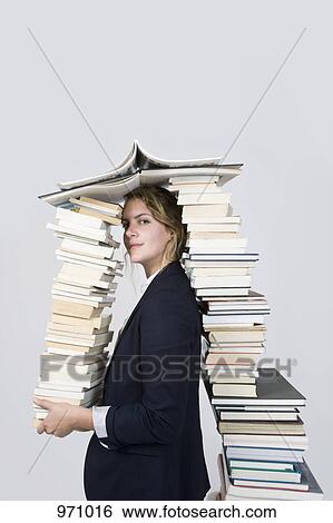 Stock Photograph - Woman surrounded by books looking at camera. Fotosearch