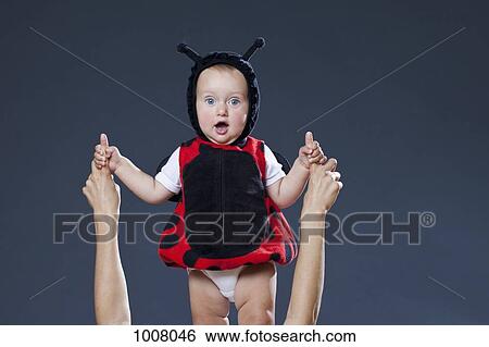A baby boy in a ladybug costume holding the fingers of a woman View Large Photo Image Stock Photograph - A baby boy in a ladybug costume holding the fingers of a woman. Fotosearch