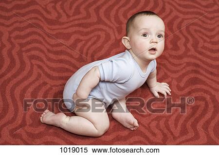 A baby boy lying on a patterned carpet View Large Photo Image Stock Photography - A baby boy lying on a patterned carpet. Fotosearch