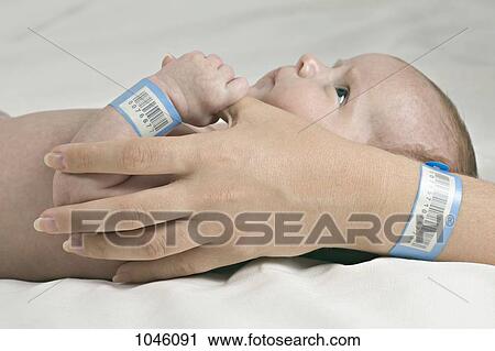 A baby holding her mother's thumb, both wearing hospital ID bracelets View Large Photo Image Stock Image - A baby holding her mother's thumb, both wearing hospital ID bracelets. Fotosearch