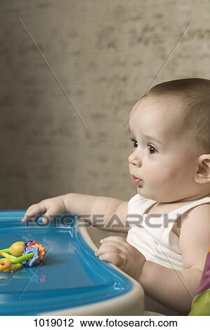 A baby in a high chair patiently waiting for food View Large Photo Image Stock Image - A baby in a high chair patiently waiting for food. Fotosearch