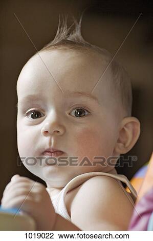 Stock Image - A baby looking seriously into the camera. Fotosearch