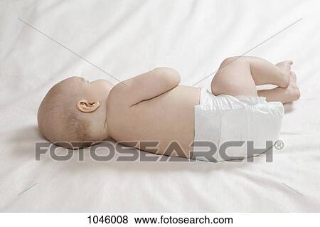Stock Photo - A baby lying its side, rear view. Fotosearch