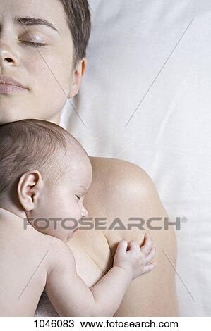 A baby lying on her mother, both sleeping View Large Photo Image Stock Image - A baby lying on her mother, both sleeping. Fotosearch