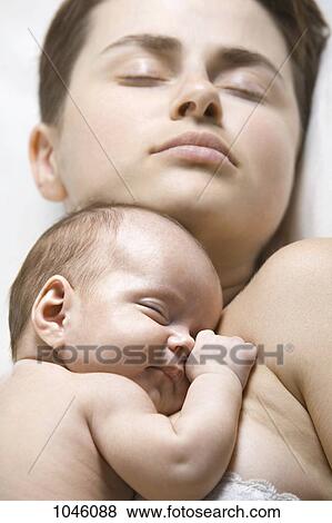 A baby lying on her mother, both sleeping View Large Photo Image Stock Photo - A baby lying on her mother, both sleeping. Fotosearch