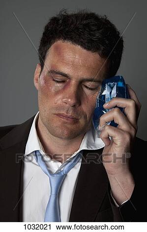 A beaten up businessman holding an ice pack on his cheek View Large Photo Image Stock Image - A beaten up businessman holding an ice pack on his cheek. Fotosearch