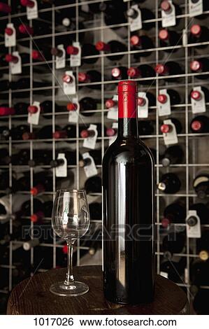 A bottle of wine and a wineglass in a cellar View Large Photo Image Stock Photograph - A bottle of wine and a wineglass in a cellar. Fotosearch