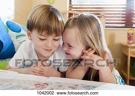 A boy and a girl reading a book together View Large Photo Image Stock Image - A boy and a girl reading a book together. Fotosearch