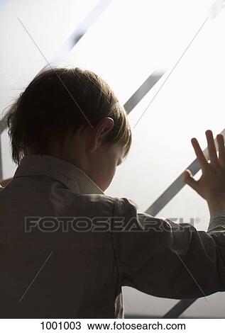 A boy looking through a frosted window View Large Photo Image Stock Image - A boy looking through a frosted window. Fotosearch