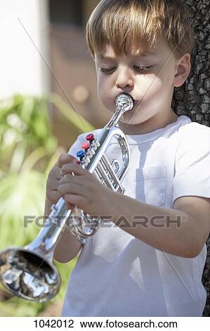 Stock Image - A boy playing a toy trumpet. Fotosearch
