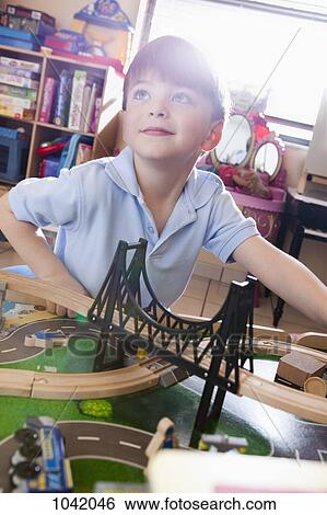 A boy playing with a train set View Large Photo Image Stock Photograph - A boy playing with a train set. Fotosearch