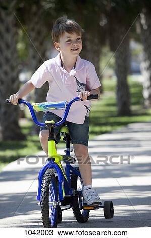A boy riding a bike View Large Photo Image Stock Image - A boy riding a bike. Fotosearch
