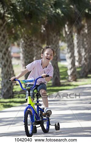 A boy riding a bike View Large Photo Image Stock Image - A boy riding a bike. Fotosearch