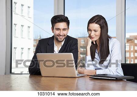A businessman and businesswoman having a meeting in a board room View Large Photo Image Picture - A businessman and businesswoman having a meeting in a board room. Fotosearch