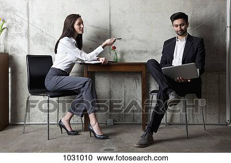 A businessman and businesswoman having a meeting in a modern office View Large Photo Image Stock Image - A businessman and businesswoman having a meeting in a modern office. Fotosearch
