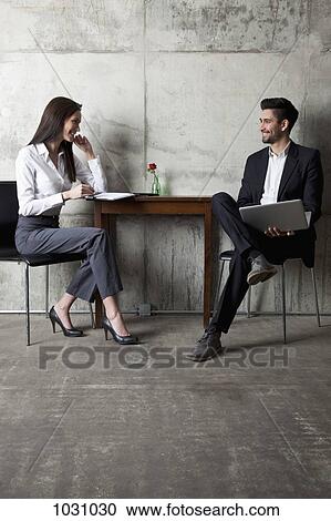 A businessman and businesswoman having a meeting in a modern office View Large Photo Image Stock Image - A businessman and businesswoman having a meeting in a modern office. Fotosearch