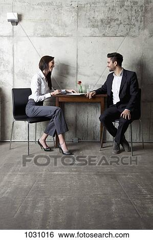 A businessman and businesswoman having a meeting in a modern office View Large Photo Image Stock Photograph - A businessman and businesswoman having a meeting in a modern office. Fotosearch