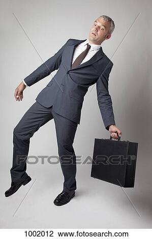 Stock Image - A businessman off balance. Fotosearch