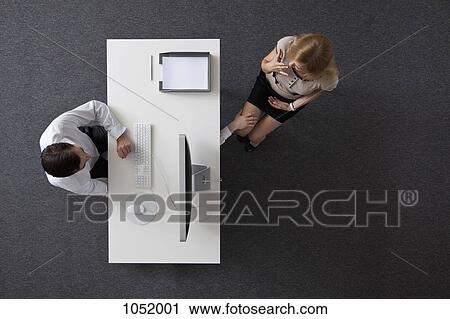 A businessman reaching under a desk to touch a woman's knee, overhead view View Large Photo Image Stock Image - A businessman reaching under a desk to touch a woman's knee, overhead view. Fotosearch
