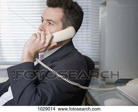 A businessman talking on a landline phone View Large Photo Image Picture - A businessman talking on a landline phone. Fotosearch