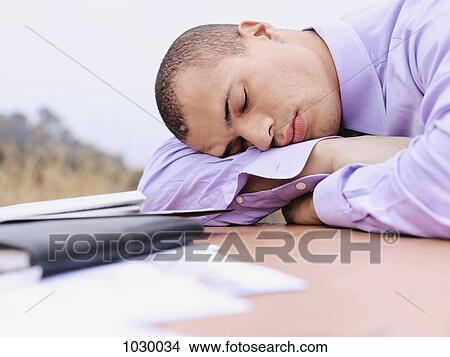 A businessman with his head resting on his arm, eyes closed, outdoors View Large Photo Image Picture - A businessman with his head resting on his arm, eyes closed, outdoors. Fotosearch