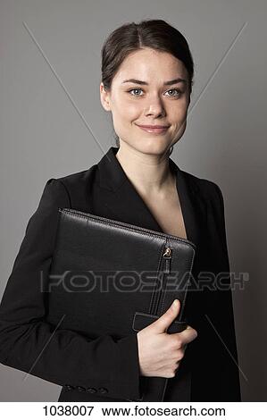 A businesswoman carrying an a leather padfolio View Large Photo Image Stock Photo - A businesswoman carrying an a leather padfolio. Fotosearch