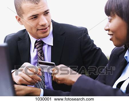 A businesswoman giving a businessman a credit card View Large Photo Image Stock Image - A businesswoman giving a businessman a credit card. Fotosearch