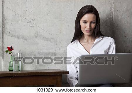 A businesswoman looking at a laptop screen View Large Photo Image Stock Photo - A businesswoman looking at a laptop screen. Fotosearch