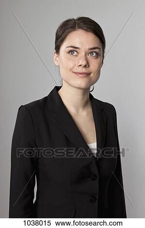 Stock Photography - A businesswoman looking up contemplatively. Fotosearch