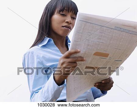 A businesswoman on a break reading a newspaper outdoors View Large Photo Image Stock Photo - A businesswoman on a break reading a newspaper outdoors. Fotosearch