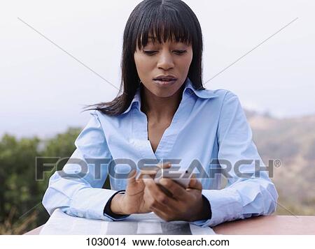 A businesswoman text messaging View Large Photo Image Picture - A businesswoman text messaging. Fotosearch