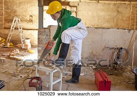 A carpenter working on a construction site View Large Photo Image Stock Photo - A carpenter working on a construction site. Fotosearch