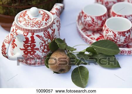 A ceramic tea set and a pear on a table View Large Photo Image Stock Photo - A ceramic tea set and a pear on a table. Fotosearch