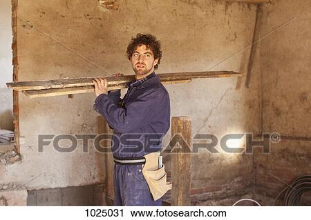 A construction worker carrying wood planks View Large Photo Image Stock Image - A construction worker carrying wood planks. Fotosearch
