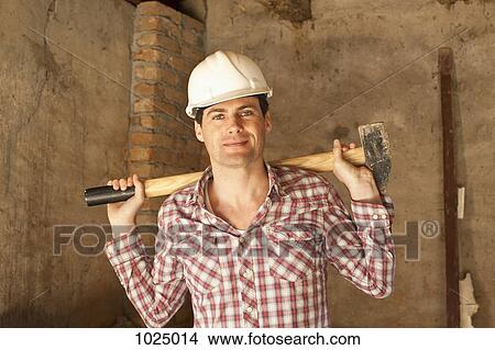 A construction worker holding a sledgehammer View Large Photo Image Picture - A construction worker holding a sledgehammer. Fotosearch