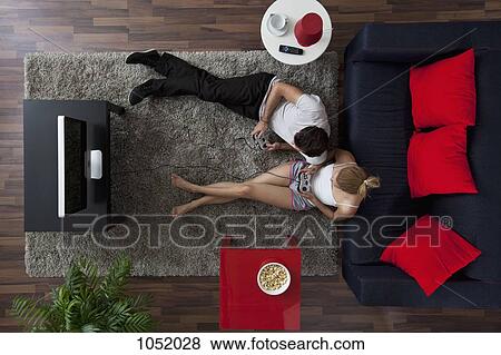 A couple playing video games in their living room, overhead view View Large Photo Image Stock Photo - A couple playing video games in their living room, overhead view. Fotosearch