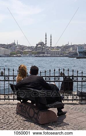 A couple sitting on a bench looking out over the Golden Horn River at the Yeni Cami Mosque, Istanbul View Large Photo Image Stock Image - A couple sitting on a bench looking out over the Golden Horn River at the Yeni Cami Mosque, Istanbul. Fotosearch
