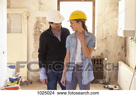 A couple standing in their house that's under renovation View Large Photo Image Picture - A couple standing in their house that's under renovation. Fotosearch