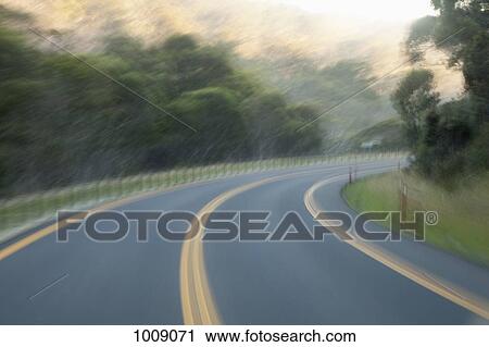Stock Image - A curve in a highway road, blurred motion. Fotosearch