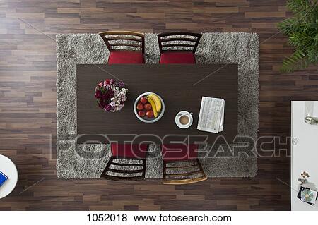 Stock Photo - A dining table with a coffee cup and newspaper, overhead view. Fotosearch