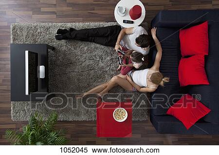 A family of three playing video games in their living room, overhead view View Large Photo Image Stock Photography - A family of three playing video games in their living room, overhead view. Fotosearch
