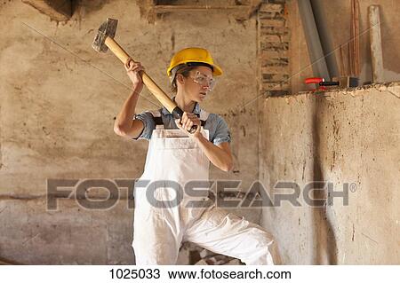 A female construction worker swinging a sledgehammer View Large Photo Image Stock Image - A female construction worker swinging a sledgehammer. Fotosearch