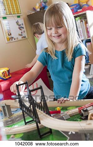Stock Photo - A girl playing with a train set. Fotosearch