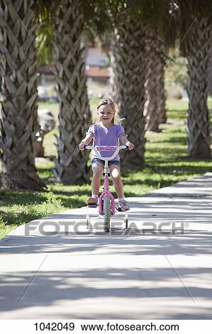 A girl riding a bike View Large Photo Image Stock Photo - A girl riding a bike. Fotosearch