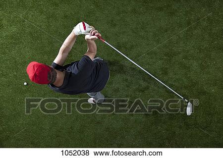 Stock Photo - A golfer swinging a golf club, overhead view. Fotosearch