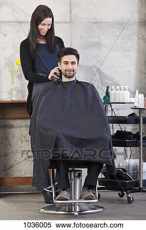 A hairdresser using clippers on a male customer View Large Photo Image Stock Photography - A hairdresser using clippers on a male customer. Fotosearch