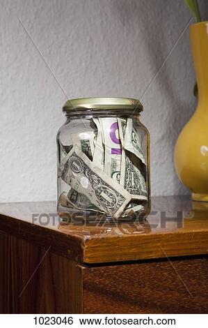 Stock Photograph - A jar full of US paper currency. Fotosearch