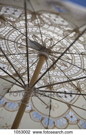 Stock Image - A lace parasol, low angle view, close-up, full frame. Fotosearch