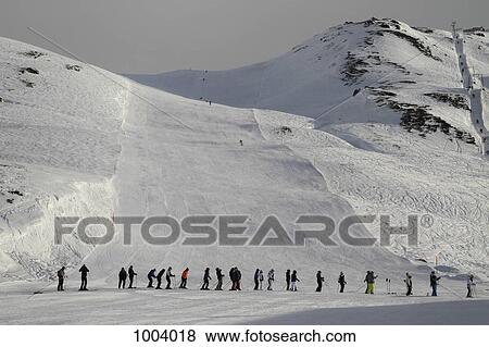 Stock Photo - A line of skiers waiting for the ski lift, Oberalp Pass, Andermatt, Uri Canton, Switzerland. Fotosearch